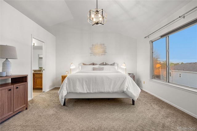 bedroom with light carpet, lofted ceiling, a chandelier, baseboards, and connected bathroom