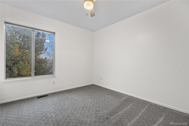 carpeted empty room with a ceiling fan and baseboards
