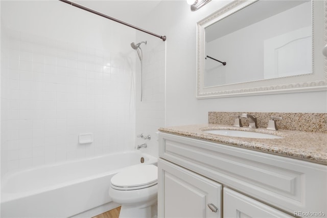 bathroom featuring toilet, tub / shower combination, vanity, and wood finished floors
