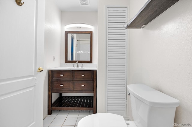 bathroom featuring toilet, a closet, vanity, and tile patterned flooring