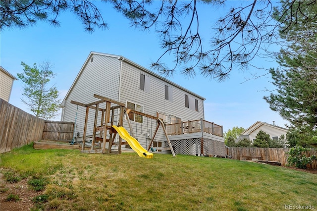 rear view of house featuring a deck and a playground