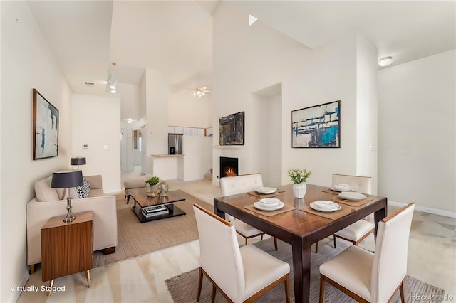 dining area with ceiling fan and a high ceiling