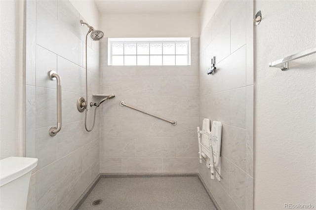 bathroom featuring toilet and tiled shower