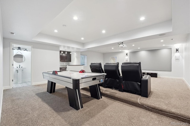 playroom featuring a raised ceiling and light carpet