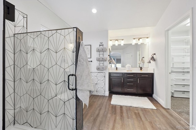 bathroom featuring vanity, hardwood / wood-style flooring, and a shower with door