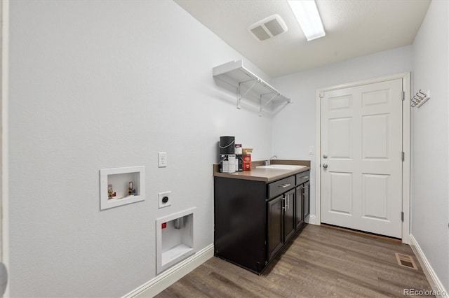 laundry area with electric dryer hookup, cabinets, sink, hookup for a washing machine, and hardwood / wood-style flooring