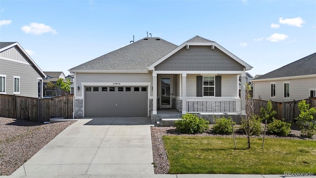 view of front of house featuring a front yard, a porch, and a garage