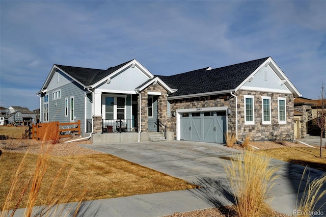 view of front facade with a garage, driveway, and stone siding