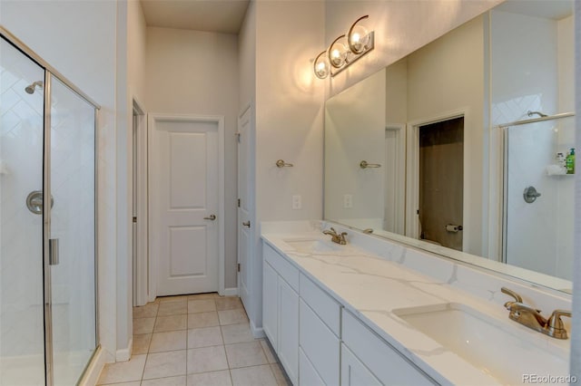 full bath featuring tile patterned floors, double vanity, a sink, and a stall shower