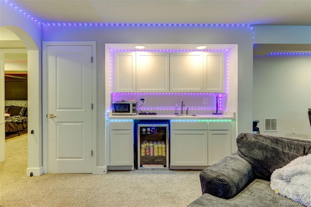 bar with bar area, visible vents, light carpet, stainless steel microwave, and wine cooler