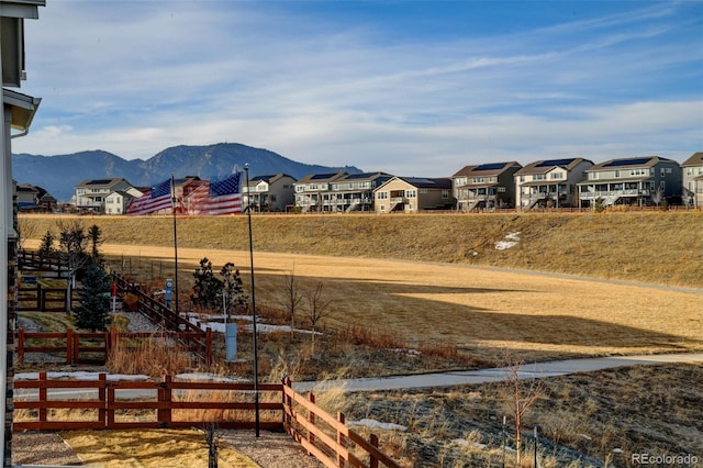view of yard with a mountain view, fence, and a residential view
