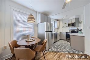 kitchen with gray cabinets, stainless steel appliances, ceiling fan, and light wood-type flooring