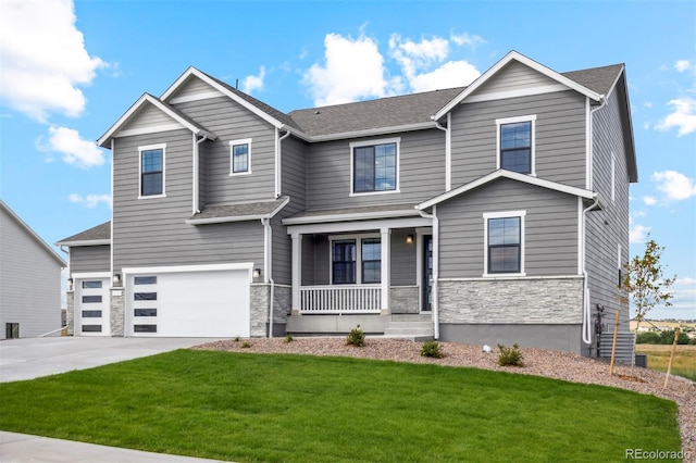 view of front of property with a front yard, covered porch, concrete driveway, a garage, and stone siding