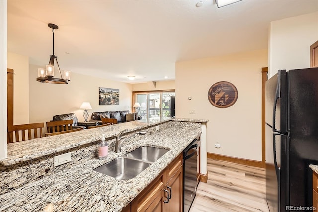 22787 US Highway 6 Unit 313, Dillon, CO 80435 - kitchen featuring black appliances, a sink, light wood-type flooring, light stone countertops, and decorative light fixtures