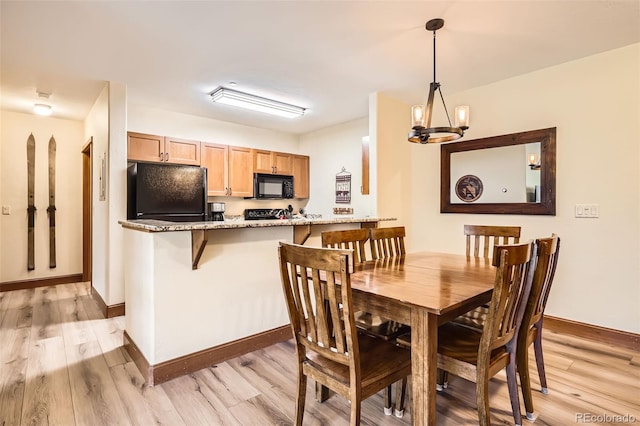 22787 US Highway 6 Unit 313, Dillon, CO 80435 - dining area featuring light wood-style flooring, a chandelier, and baseboards