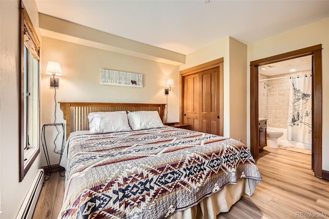 22787 US Highway 6 Unit 313, Dillon, CO 80435 - bedroom with a baseboard radiator, a closet, light wood-style flooring, ensuite bathroom, and baseboards