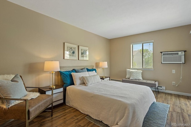 bedroom featuring wood finished floors, baseboards, and a wall mounted air conditioner