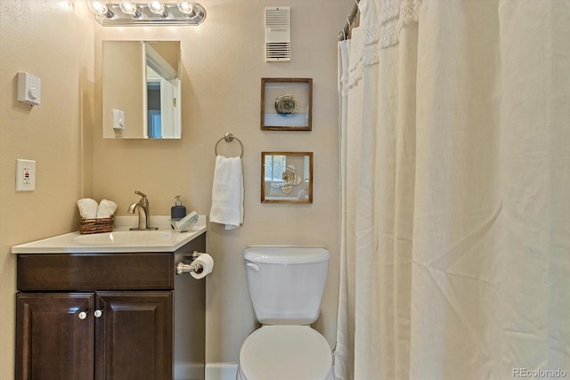 bathroom with vanity, toilet, and visible vents