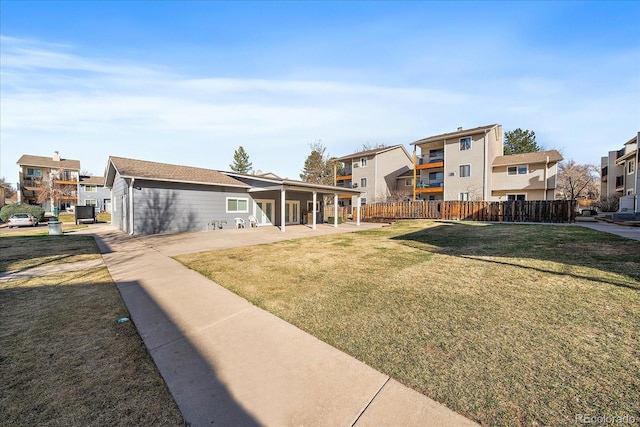 view of yard with a patio, fence, and a residential view