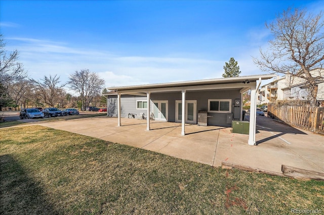 back of property with a patio area, a lawn, and fence