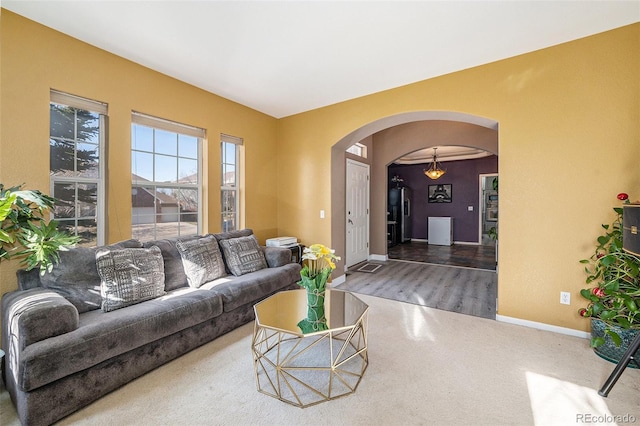 living room featuring baseboards and arched walkways