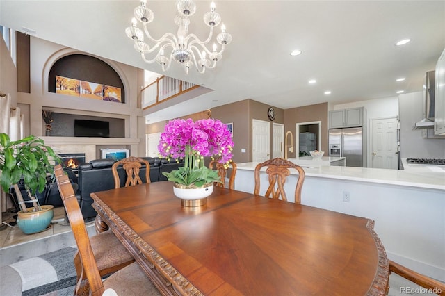 dining area featuring a chandelier, recessed lighting, and a premium fireplace