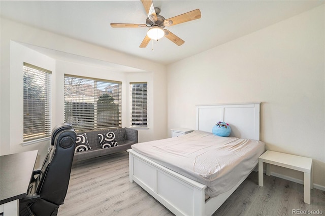 bedroom with baseboards, ceiling fan, and light wood finished floors