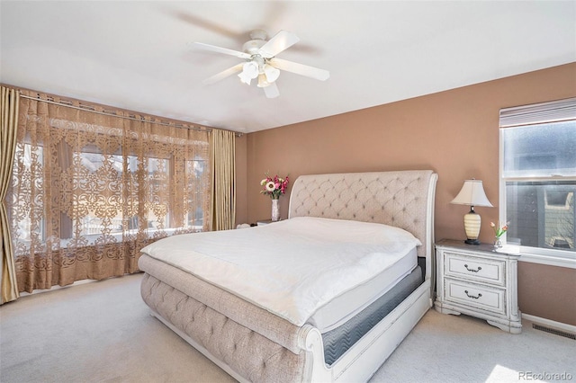 bedroom with light colored carpet, visible vents, and ceiling fan