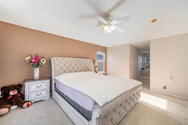 bedroom with a ceiling fan, light colored carpet, and baseboards