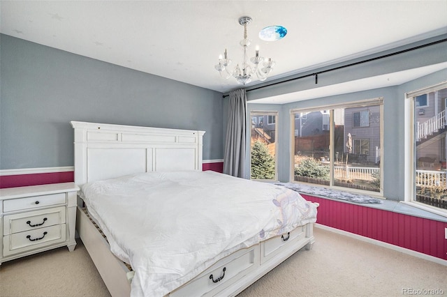 bedroom with a notable chandelier, light colored carpet, and baseboards