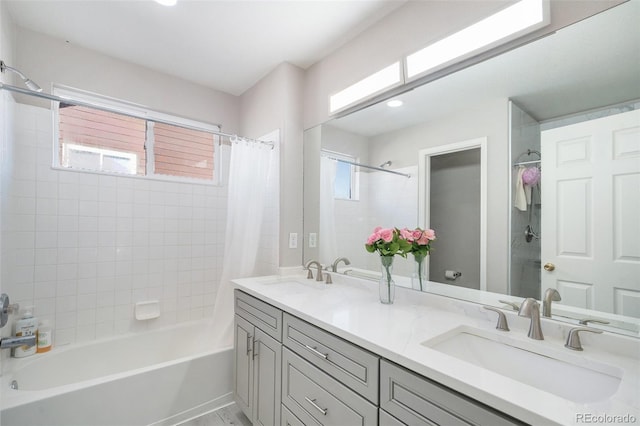 bathroom with double vanity, shower / bathtub combination with curtain, and a sink