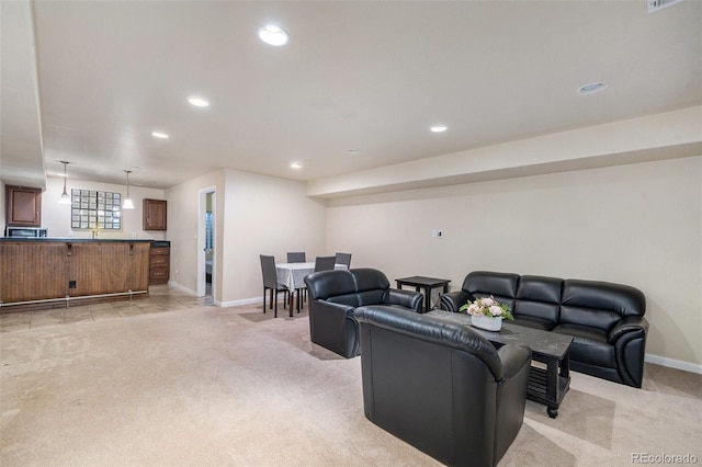 living area with recessed lighting, light colored carpet, and baseboards