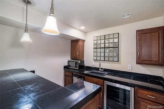 kitchen with tile countertops, beverage cooler, a sink, stainless steel appliances, and pendant lighting