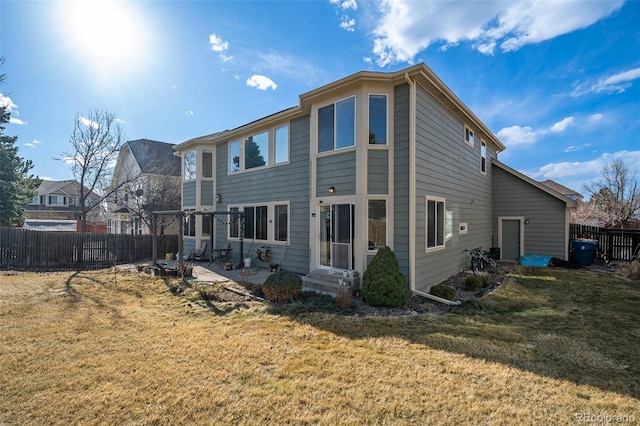 back of property featuring a lawn, a fenced backyard, and a patio area