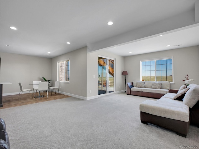 carpeted living area featuring recessed lighting, baseboards, and visible vents