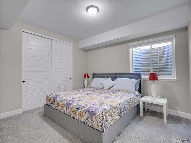 carpeted bedroom with baseboards and a closet