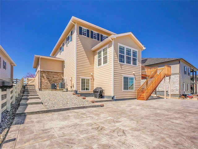 rear view of house featuring stairway, a deck, a patio area, and central air condition unit