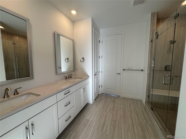 bathroom with vanity and a shower with door