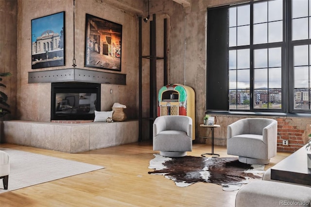 sitting room featuring a glass covered fireplace and wood finished floors