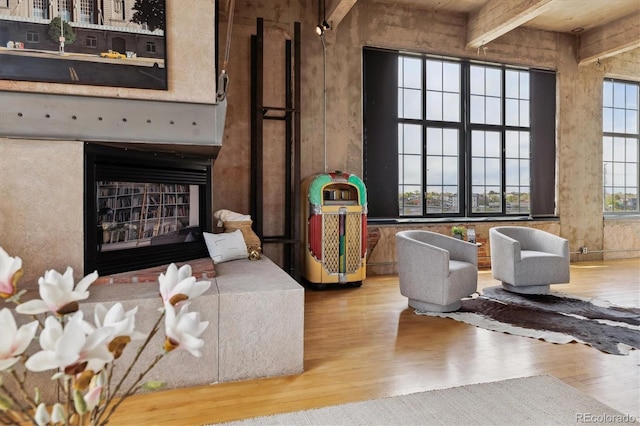 interior space featuring beamed ceiling, a fireplace, and wood finished floors