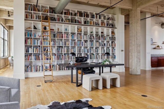 sitting room with bookshelves and wood finished floors