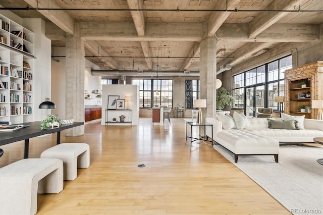living area with wood finished floors, wooden ceiling, and beamed ceiling