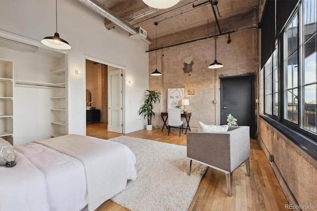 bedroom featuring wood-type flooring and a towering ceiling