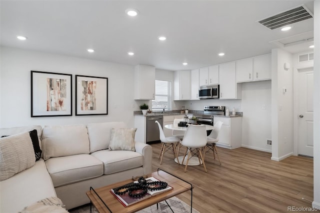 living room with sink and light hardwood / wood-style floors