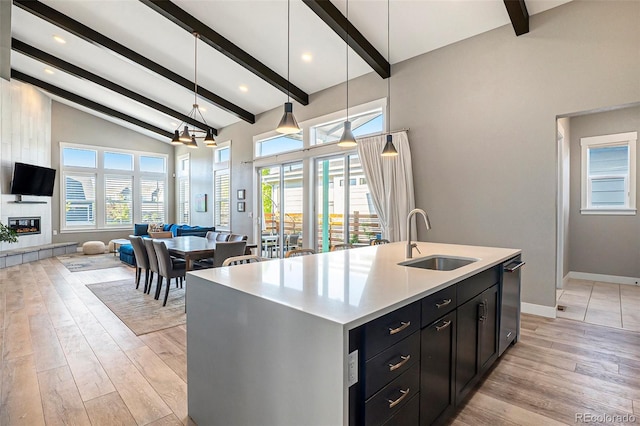 10179 E 59th N Pl, Denver, CO 80238 - kitchen featuring a sink, open floor plan, beam ceiling, dark cabinets, and baseboards