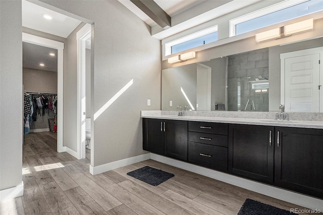 10179 E 59th N Pl, Denver, CO 80238 - bathroom with a stall shower, double vanity, wood finished floors, baseboards, and a spacious closet
