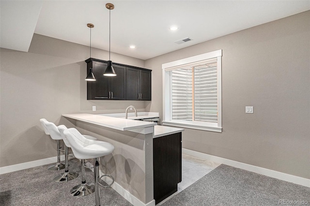 10179 E 59th N Pl, Denver, CO 80238 - kitchen featuring light countertops, a kitchen bar, baseboards, hanging light fixtures, and recessed lighting