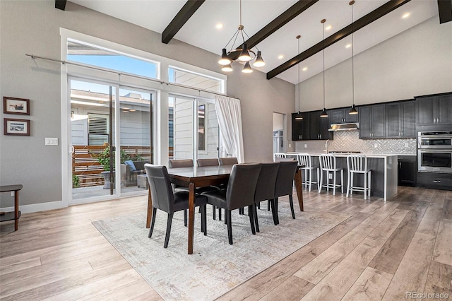 10179 E 59th N Pl, Denver, CO 80238 - dining space with beamed ceiling, light wood-style flooring, high vaulted ceiling, healthy amount of natural light, and a chandelier