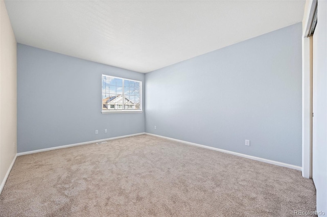 empty room featuring baseboards and carpet