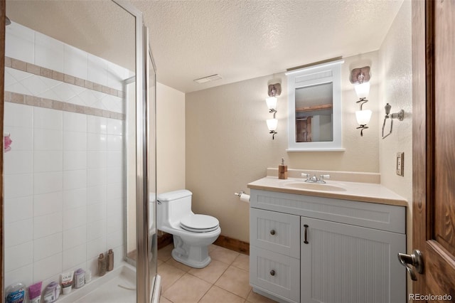 bathroom with tile patterned flooring, vanity, toilet, a textured ceiling, and a shower stall